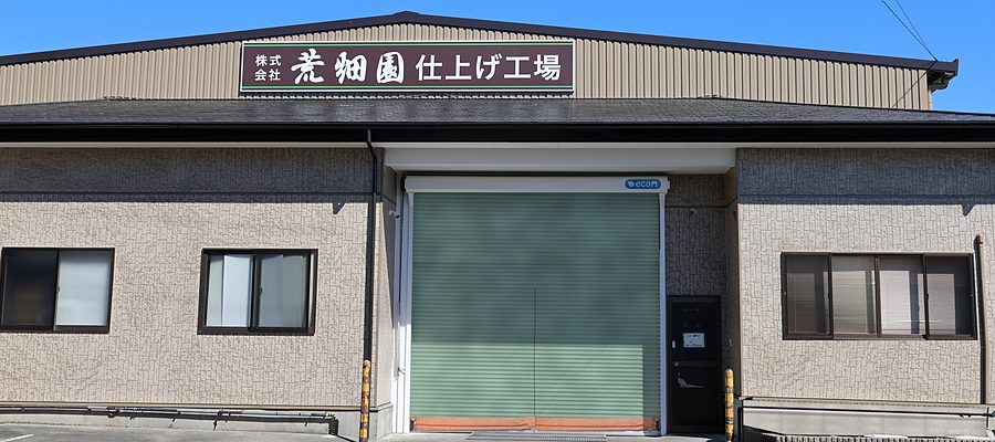 「株式会社 荒畑園 仕上げ工場」の看板を掲げた仕上げ工場の外観