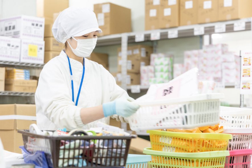 出荷場の棚からご注文の商品をそろえるスタッフ