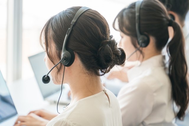 ヘッドセットでお客様からの電話に応対するオペレーター